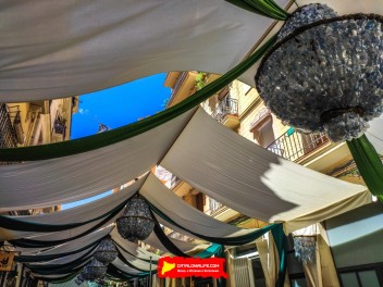 Улица Верди (Carrer de Verdi): «Крытая площадь» — дань уважения временным крытым площадкам, возводившимся в Грасии для праздников с XIX века до 70-х годов. (Un homenatge als envelats que s’aixecaven a Gràcia durant la festa major, des del segle XIX fins als anys 70.) - Феста Майор де Грасиа 2024 (Festa Major de Gràcia 2024)